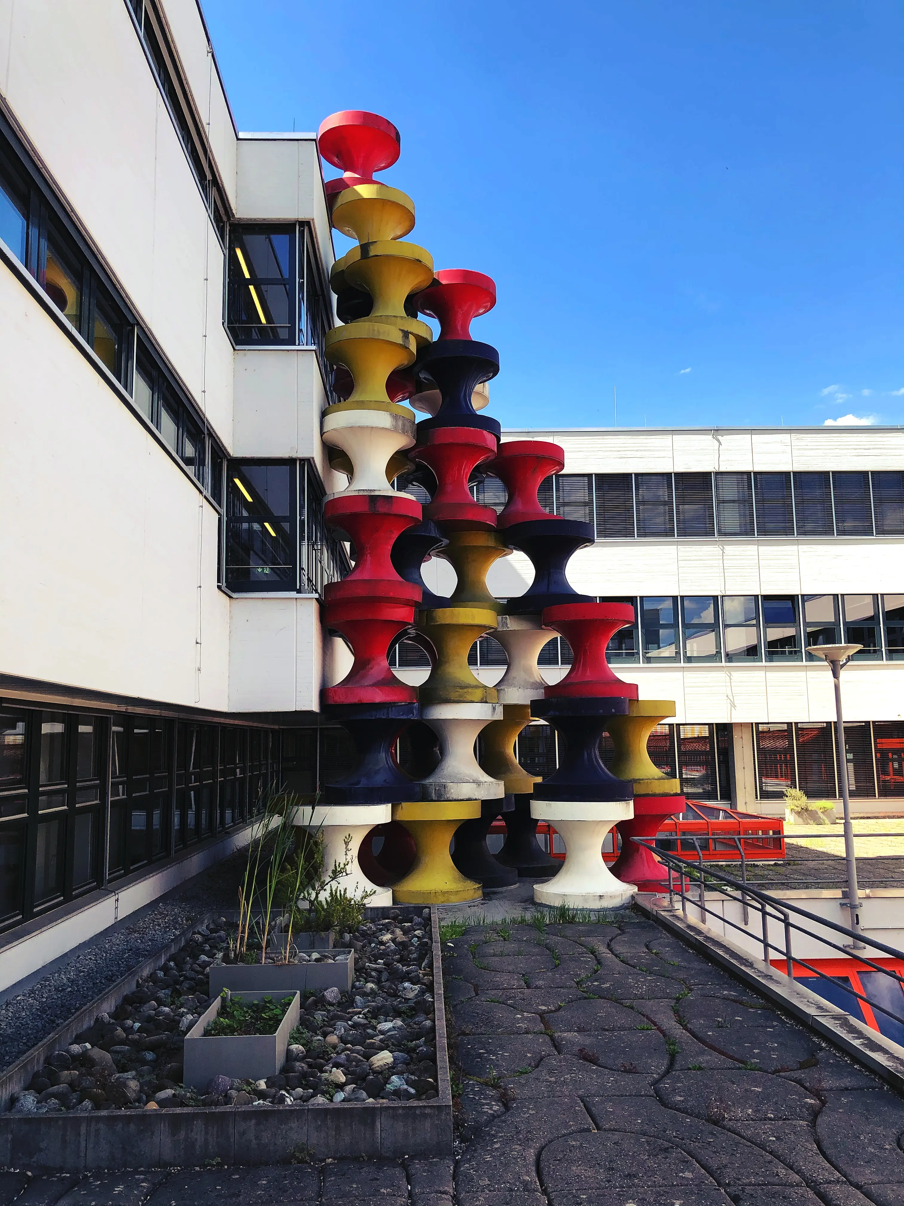 Die bunten Figuren von Gottfried Bechtold lehnen sich an das Uni Gebäude der Stadt Konstanz.